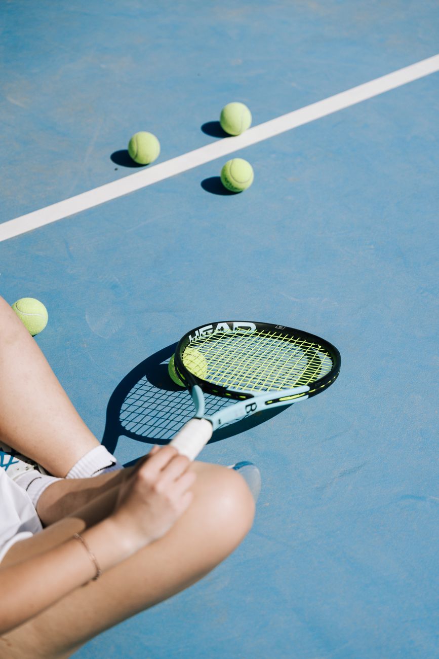 sitting woman with tennis racket and balls